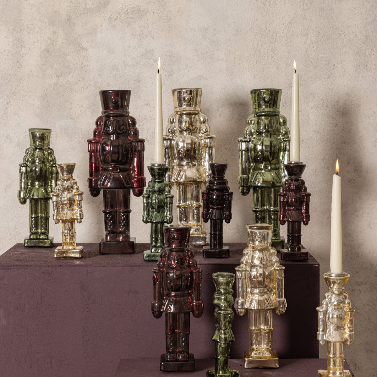 Set Van 2 Breyen Notenkrakers Glas Goud Glanzend van PTMD, sfeerbeeld met glazen notenkrakers in bordeaux, groen en goud op een kast
