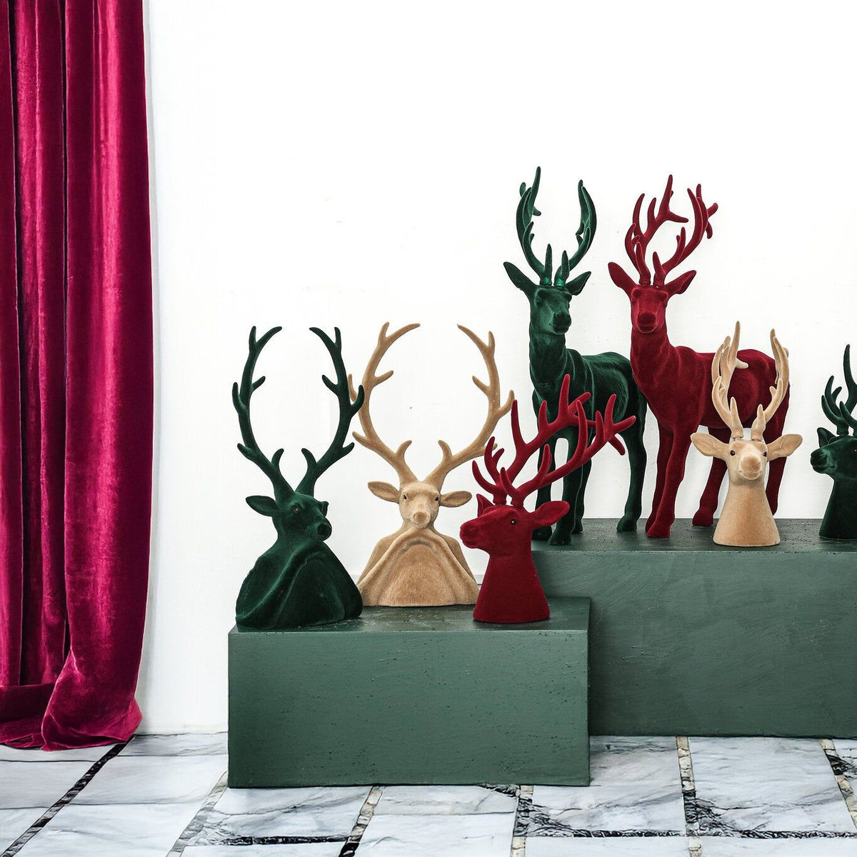 Yule Rendierkop Beige Small van PTMD, rendieren en kerstboompjes in drie kleuren op een groene kast