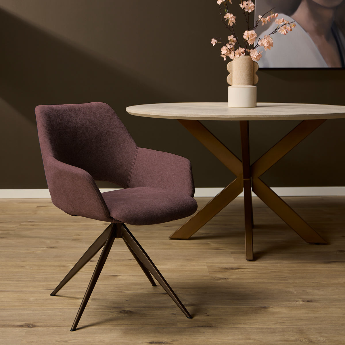 Roze eetkamerstoel Daisy aan een ronde eettafel in een sfeervol donker interieur