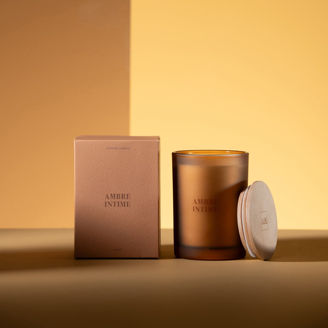 Geurkaars Accords Essentiels Ambre Intime 38 Uur van J-Line met bijpassende doos in een sfeervolle okerkleurige setting
