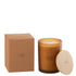 Geurkaars Accords Essentiels Ambre Intime 52 Uur van J-Line, okerkleurige glazen pot met houten deksel naast de geschenkdoos
