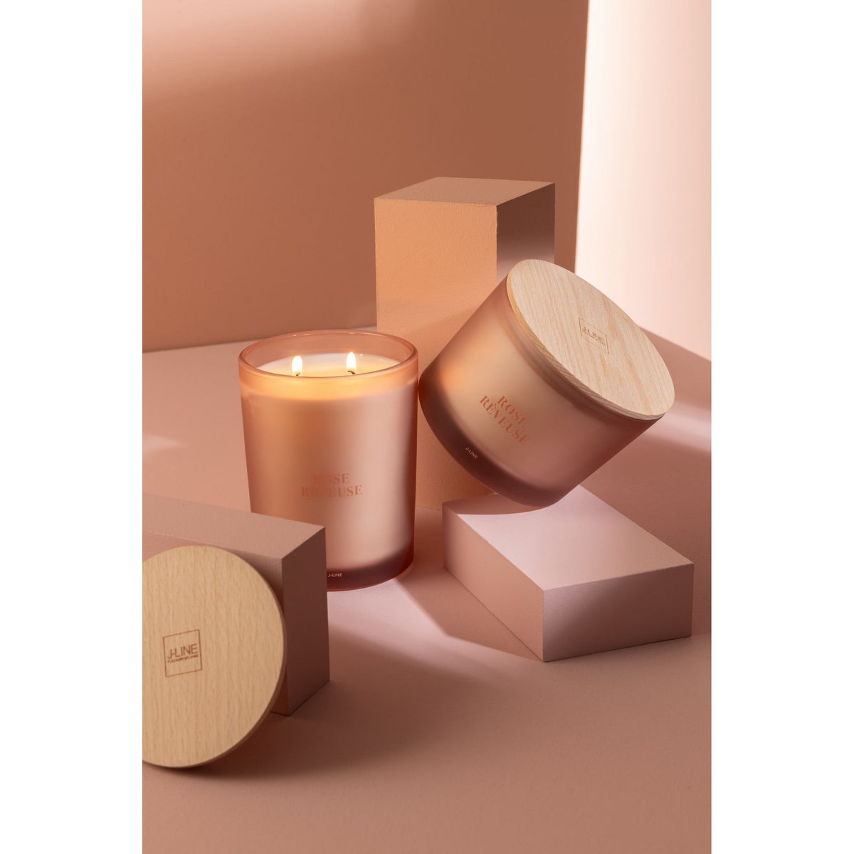 Geurkaars Accords Essentiels Rose Rêveuse 28 Uur van J-Line op decoratieve blokken in een warme sfeerfoto