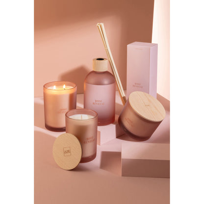 Geurkaars Accords Essentiels Rose Rêveuse 38 Uur van J-Line op decoratieve blokken in een warme sfeerfoto