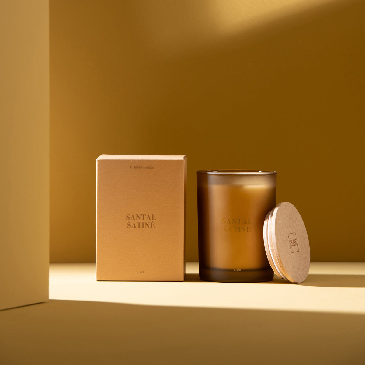 Geurkaars Accords Essentiels Santal Satiné 38 Uur van J-Line met bijpassende doos in een sfeervolle gele setting