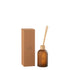 Geurstokjes Accords Essentiels Ambre Intime 250ml van J-Line, okerkleurige glazen fles met geurstokjes naast de geschenkdoos