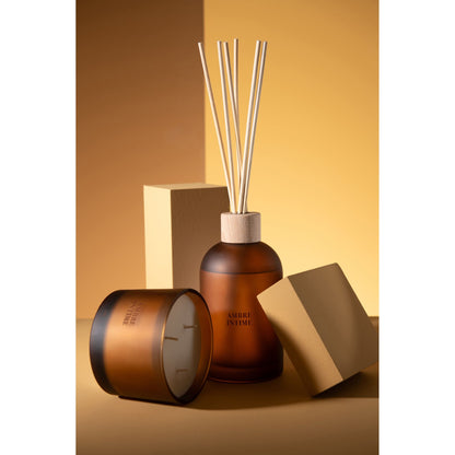 Geurstokjes Accords Essentiels Ambre Intime 550ml van J-Line samen met bijpassende geurkaars uit de Ambre Intime lijn