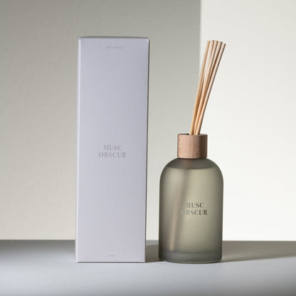 Geurstokjes Accords Essentiels Musc Obscur 250ml van J-Line met bijpassende doos in een sfeervolle grijze setting