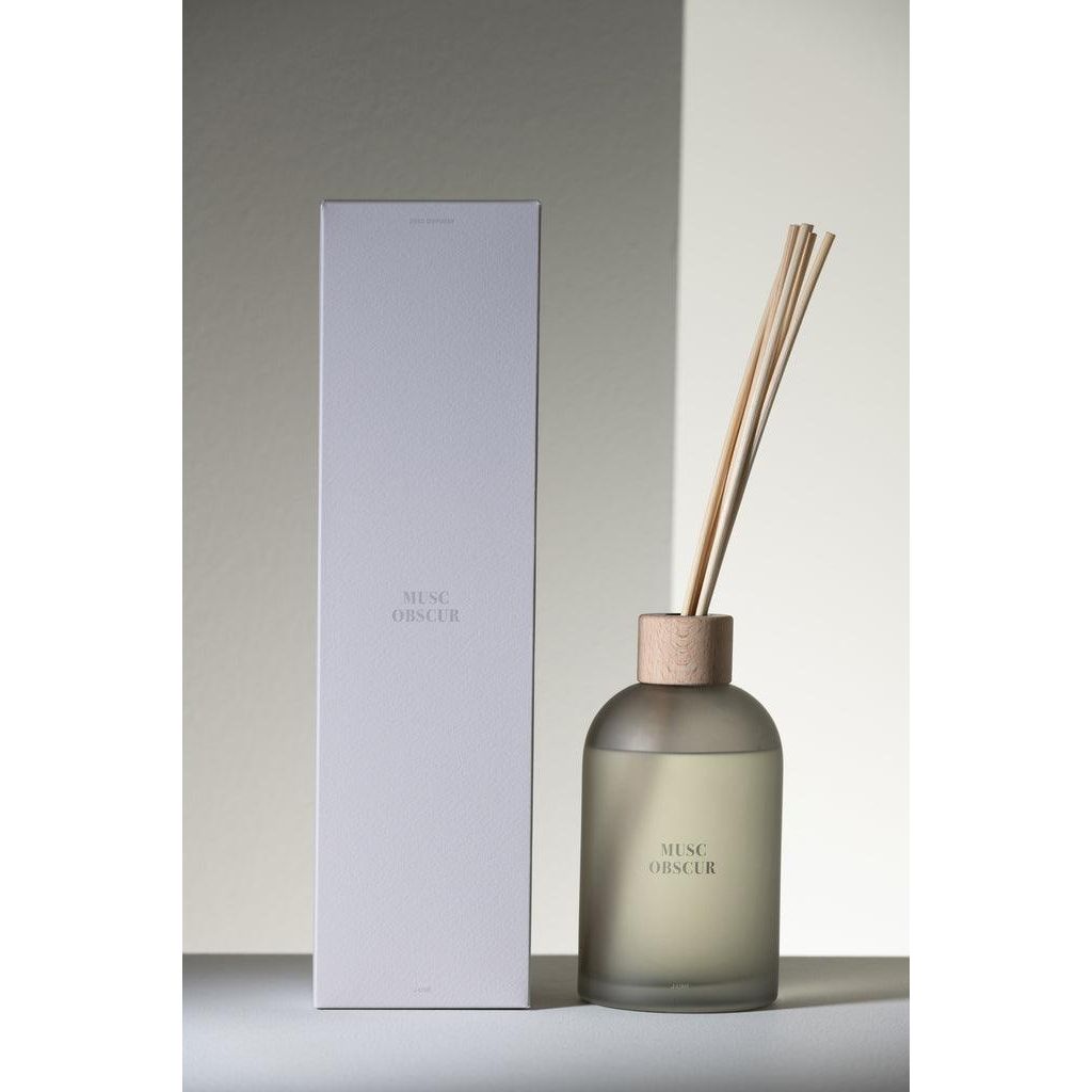 Geurstokjes Accords Essentiels Musc Obscur 550ml van J-Line op decoratieve blokken in een warme sfeerfoto