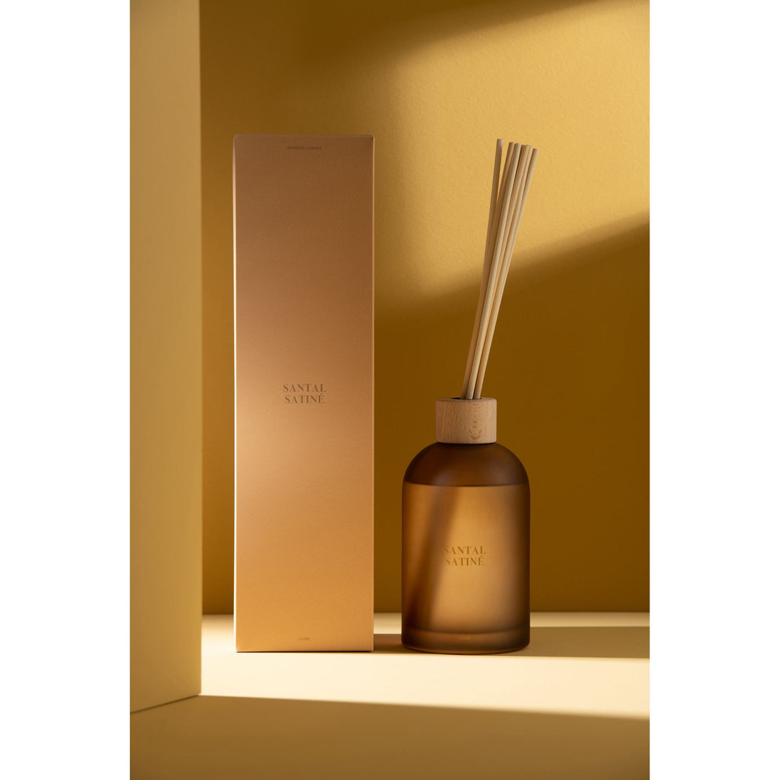 Geurstokjes Accords Essentiels Santal Satiné 550ml van J-Line met bijpassende doos in een sfeervolle gele setting