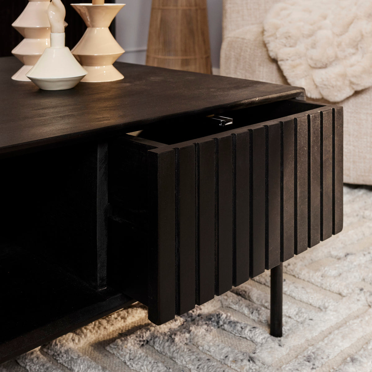 Detail van het verticale ribbelfront op de zwarte lades van de Madison salontafel