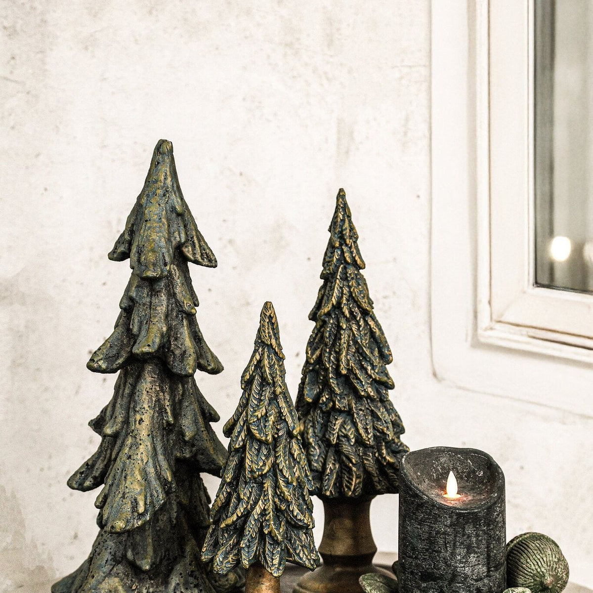 Set Van 2 Thao Kerstbomen Cement Donkergroen Goud van PTMD, donkergroene kerstboompjes van cement op een dienblad met kaarsen