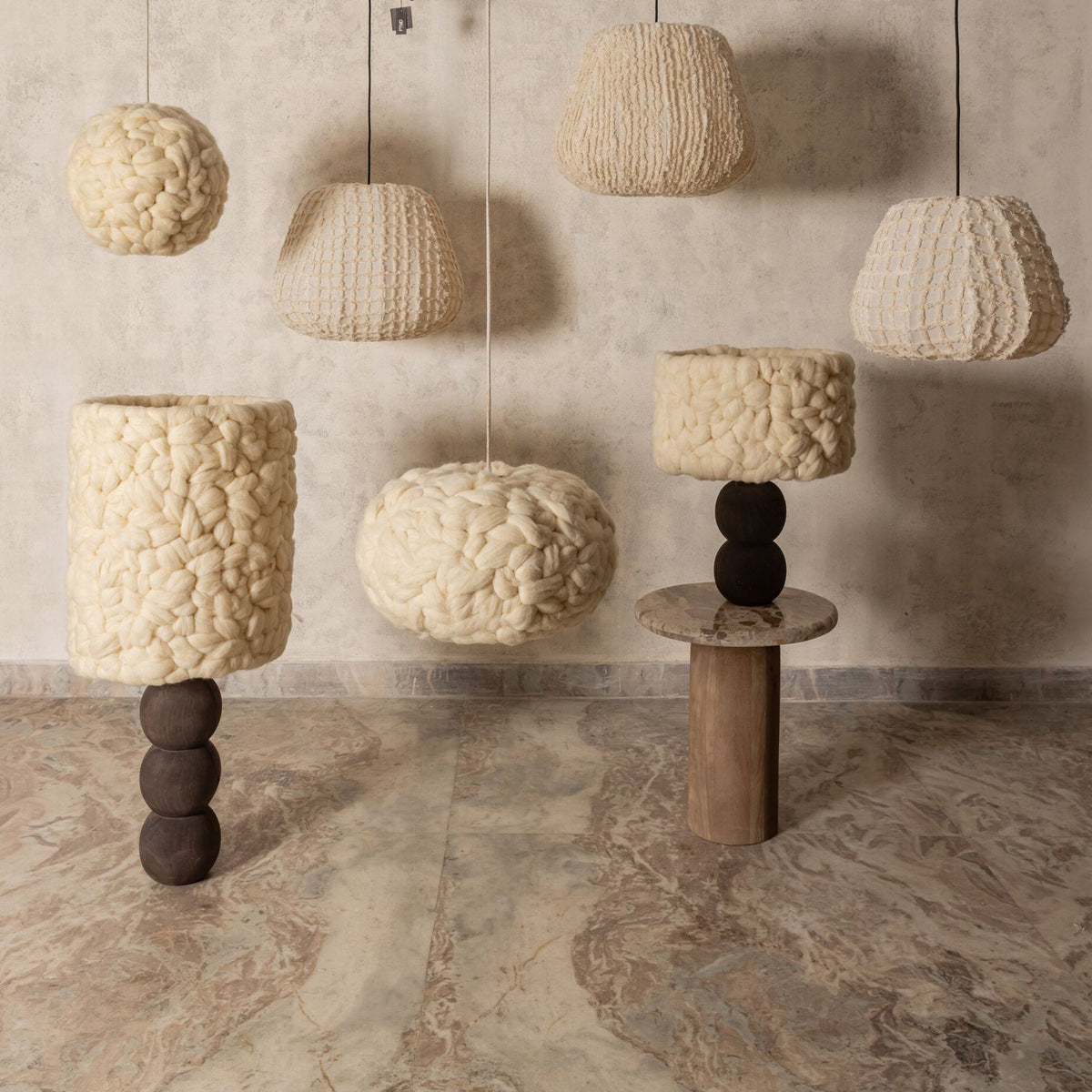 Sfeerfoto Tayma lampen van PTMD, crème katoenen hanglampen naast sculpturale tafellampen