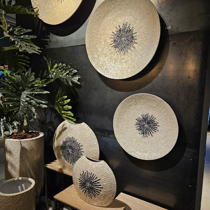 Wandpaneel Vojtech Wit Schelpen Bamboe Large van PTMD, drie schelpenpanelen aan een donkere muur met planten